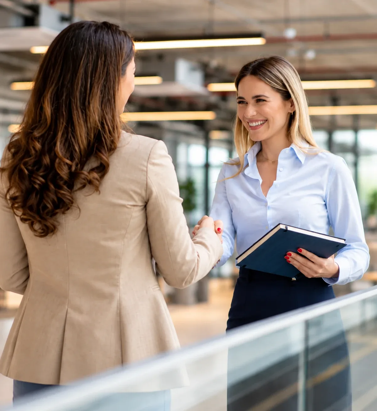 Une poignée de main souriante entre une recruteuse et une collaboratrice